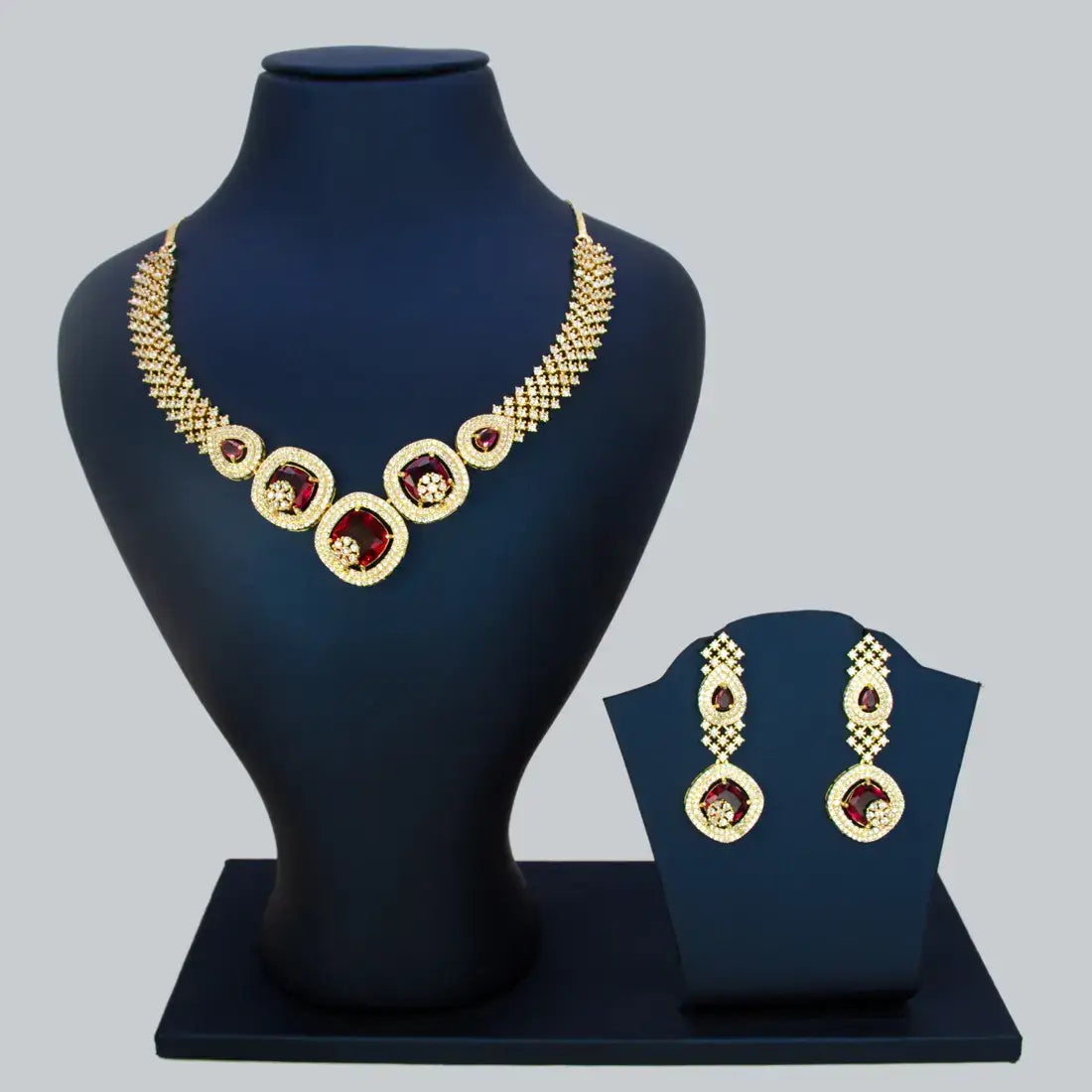 CZ Stone Necklace Set featuring gold-plated design with ruby red stones, displayed on a jewelry bust.