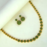Premium Gold Plated Round Emerald Necklace Set featuring a necklace and matching earrings with round green stone-encrusted disc motifs, displayed on a white surface.