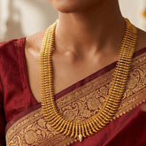 Kerala Traditional Gold Plated Puli Nakham Long Necklace displayed on a model wearing a sari.