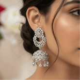 A close-up lifestyle shot of a woman wearing highly detailed silver-toned Rhodium-Plated American Diamond Bridal Jhumka, set against a softly blurred background.