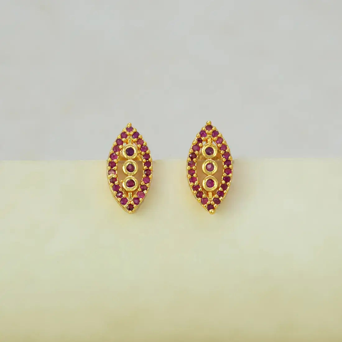 Marquise Ruby Stone Gold-plated Stud Earrings featuring three graduated ruby stones in elegant design.