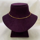 A short gold-plated designer box chain necklace displayed on a dark purple velvet jewelry bust against a light beige background.