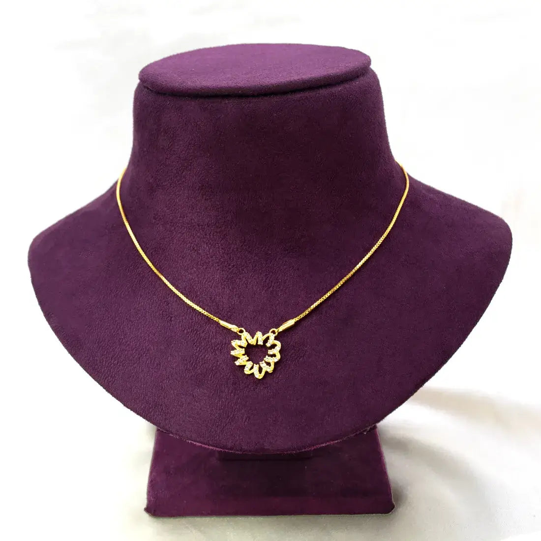 Stunning Gold-Plated CZ Pendant Chain displayed on a purple velvet bust showcasing a floral pendant design.