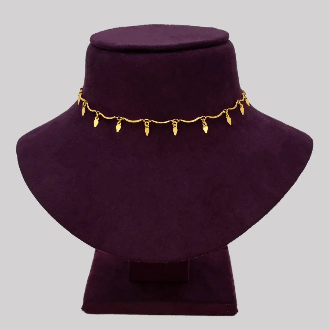 Gold Plated Wavy Chain Elakkathali Necklace displayed on a black velvet bust showcasing its elegant design.