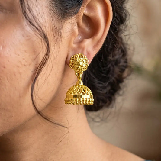 Net Design Gold Plated Filigree Jhumka Earrings showcased on a model's ear, highlighting exquisite temple jewelry craftsmanship.