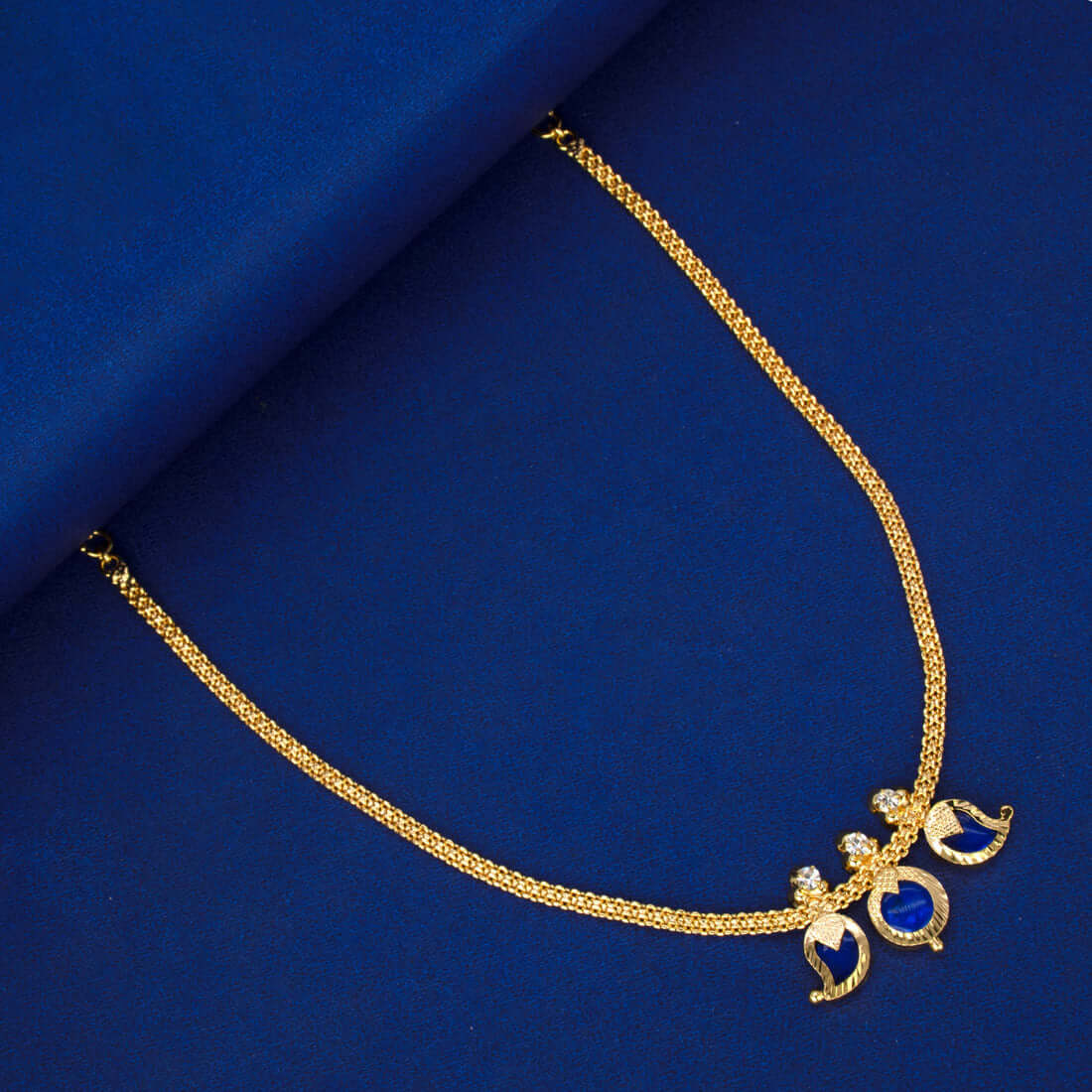 Simple Three Petal Gold Plated Mango Necklace with blue mango CZ stones and round pendant on a blue background.