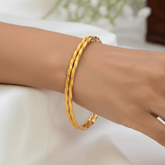 Simple Gold Plated Twisted Bangles worn on a wrist, showcasing their delicate spiral texture and minimalist design.