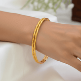 Simple Gold Plated Twisted Bangles worn on a wrist, showcasing their delicate spiral texture and minimalist design.