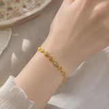 Gold Plated Stones and Outline Heart Bracelet displayed on a hand, showcasing alternating heart links and sparkling stones.