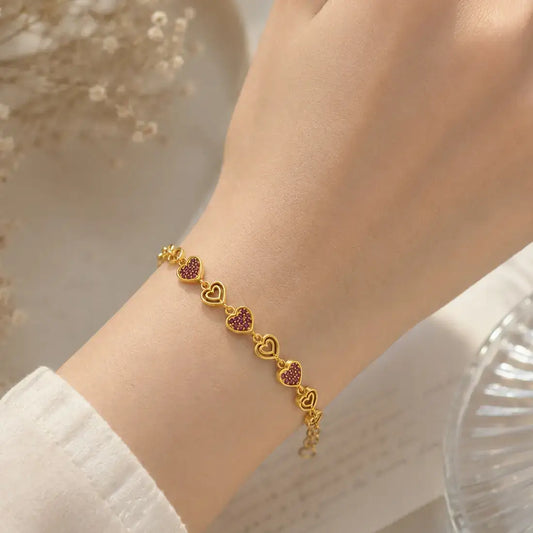 Gold Plated Stones and Outline Heart Bracelet worn on model's wrist, featuring heart links with sparkling stones.