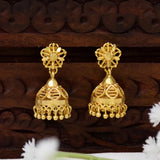 A pair of South Indian Medium Jhumki Earrings For Women with floral tops and bell-shaped dangling bells, displayed on a carved dark wood surface.