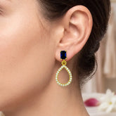 Sparkling Blue Sapphire Stone Studs CZ Drop Earrings worn on a model's ear showcasing elegance and glamour.