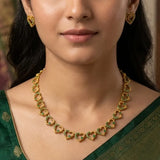 Victorian Antique Gold Stone Heart Necklace Set worn with matching earrings, featuring heart-shaped links and green stones.