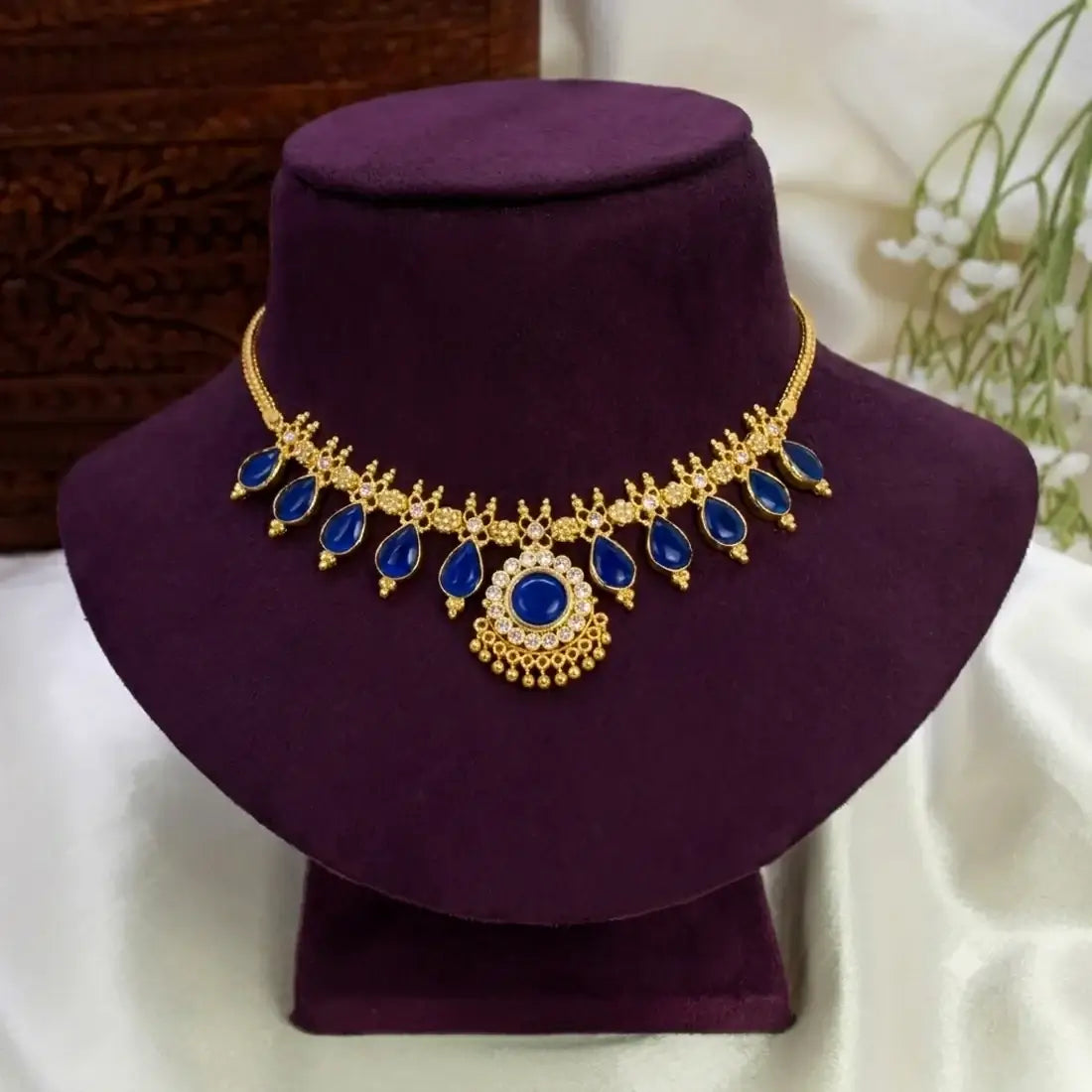 Traditional Gold-Plated Blue Enamel Teardrop Necklace displayed on a velvet bust against a soft backdrop.