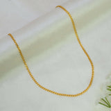 A delicateUnsex Gold-plated Double-link Chain necklace draped in a U-shape on a soft, off-white textured fabric background.