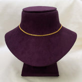 A delicate Unsex Gold-plated Double-link Chain necklace displayed on a dark purple velvet jewellery bust against a light off-white background.