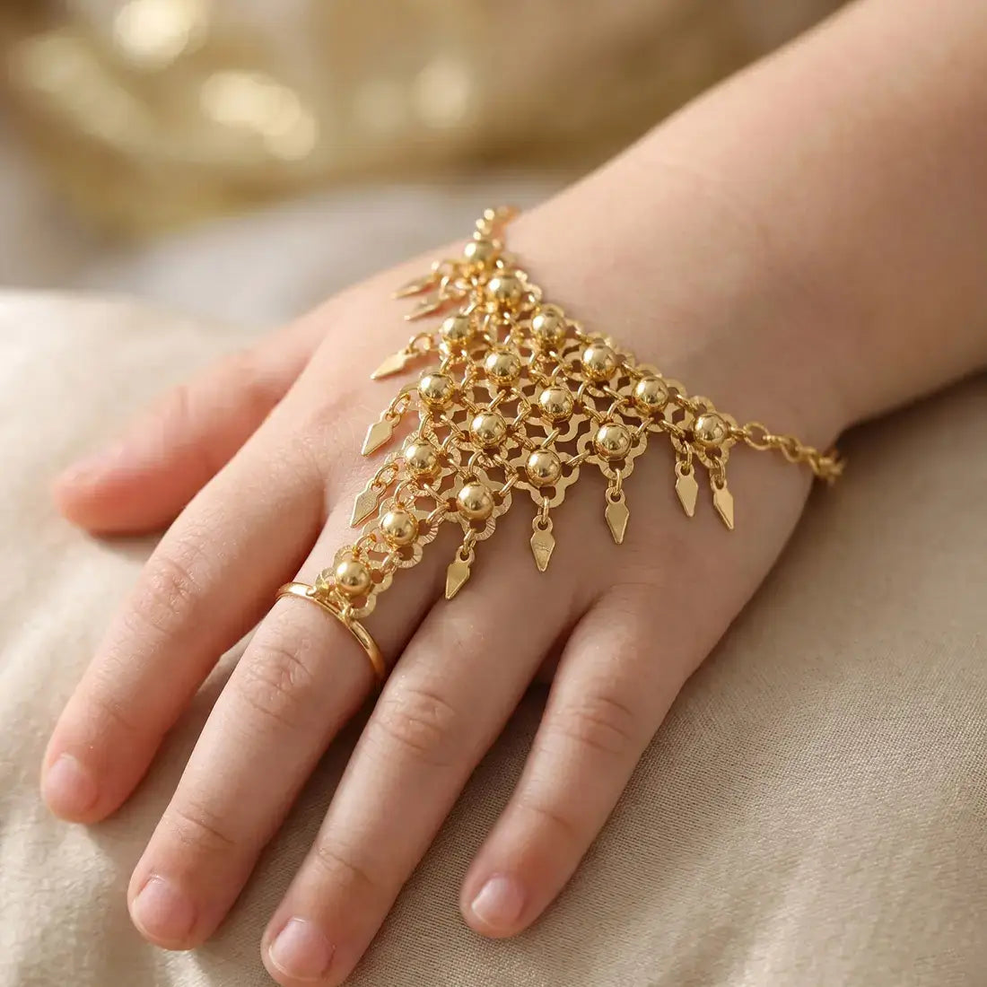 Alluring Gold Plated Finger Ring Set For Kids on a child's hand, featuring intricate gold design and adjustable fit.