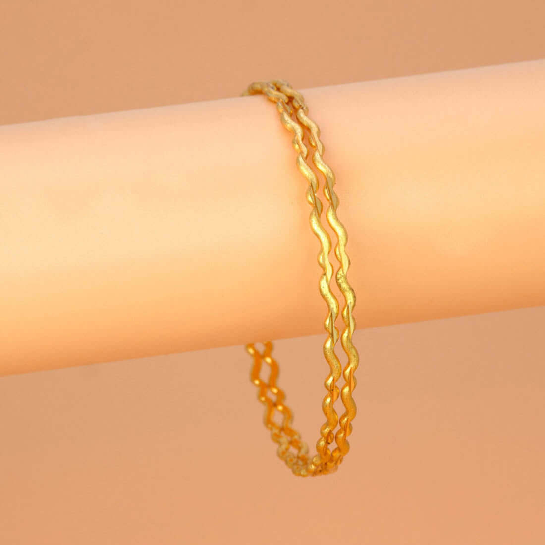 Delicate Gold Plated Wave Pattern Bangles displayed on a soft background, showcasing their elegant design and sheen.