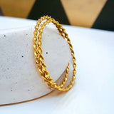 Elegant Gold Plated Twisted Spiral Bangles showcasing a stunning spiral design on a minimalist display.