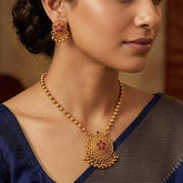Close-up of a woman wearing Antique Kemp Mandala Pendant Necklace Set and matching earrings, showcasing detailed craftsmanship.