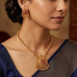 Close-up of a woman wearing Antique Kemp Mandala Pendant Necklace Set and matching earrings, showcasing detailed craftsmanship.