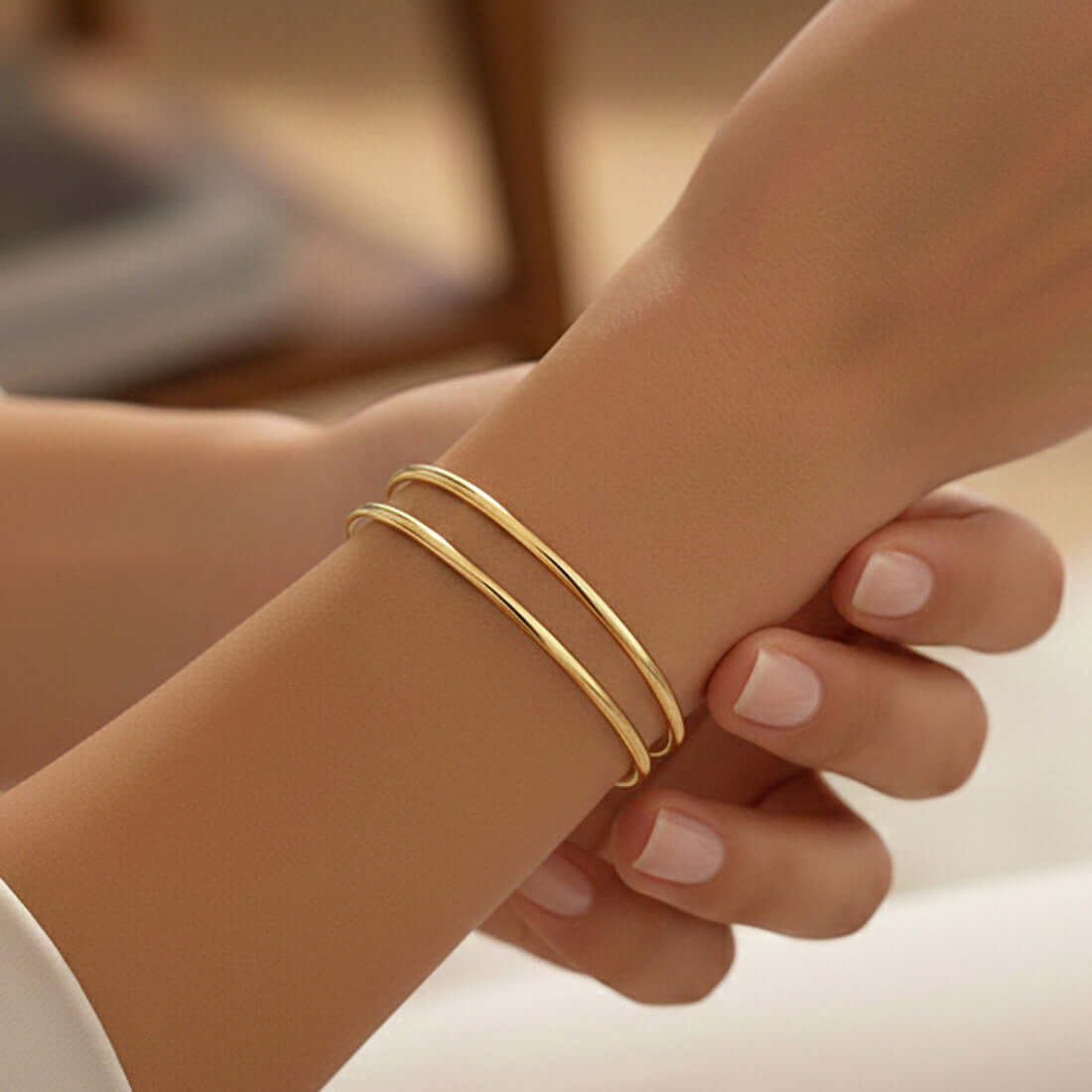 Close-up of a hand wearing Gold Plated Thin Plain Bangles, showcasing elegance and minimalist design.