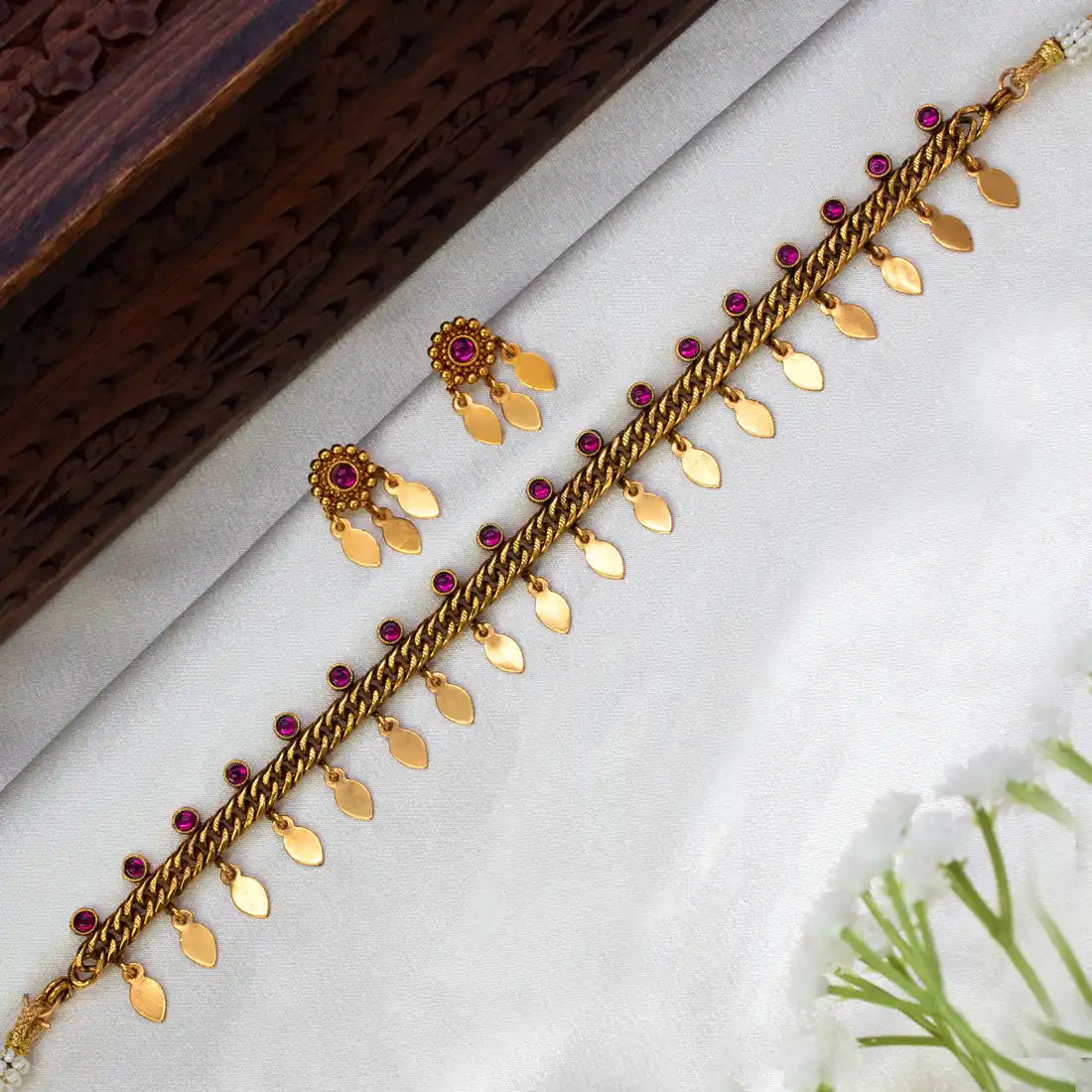 Antique Gold Plated Curb Link Elakkathali Choker Set with gold leaf danglers and ruby-toned kemp stones.