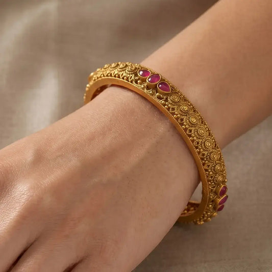 Antique Gold Plated Kemp Stone Kada Bangle worn on wrist showcasing intricate design and ruby red stones.