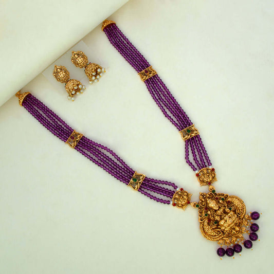 Antique Gold Lakshmi Pendant Beaded Long Necklace Set with purple beads and jhumka earrings.