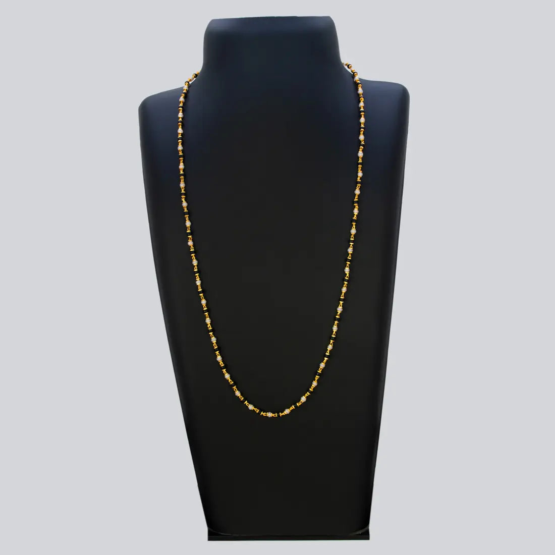 Gold Plated Black and White Pearl Chain Necklace for Women displayed on a black jewelry stand.