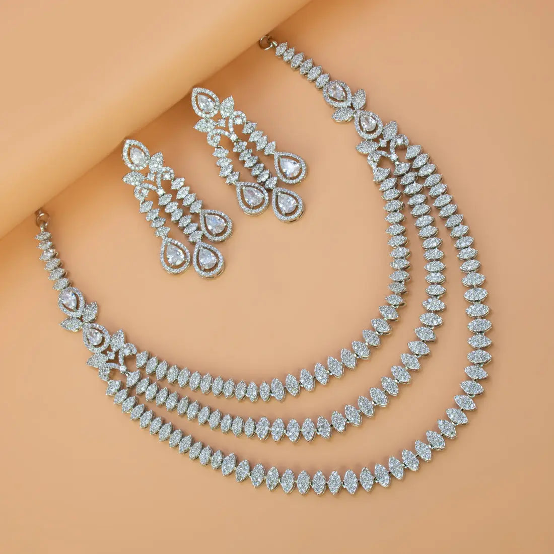 Rhodium Plated American Diamond necklace and earrings on a model against a beige background