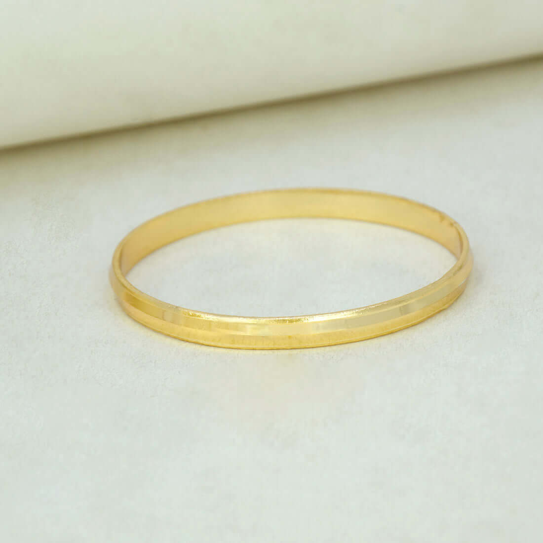 Kada-Style Gold Plated Bangle for Baby Boys resting on a soft surface, showcasing its elegant design.