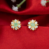 Gold Plated Pastel Central Stone CZ Flower Studs with mint green stone on red background.