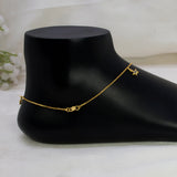 A delicate gold-plated crystal star charm anklet with a small star charm and a heart-shaped connector, displayed on a black foot-shaped jewelry stand against a soft white fabric background.