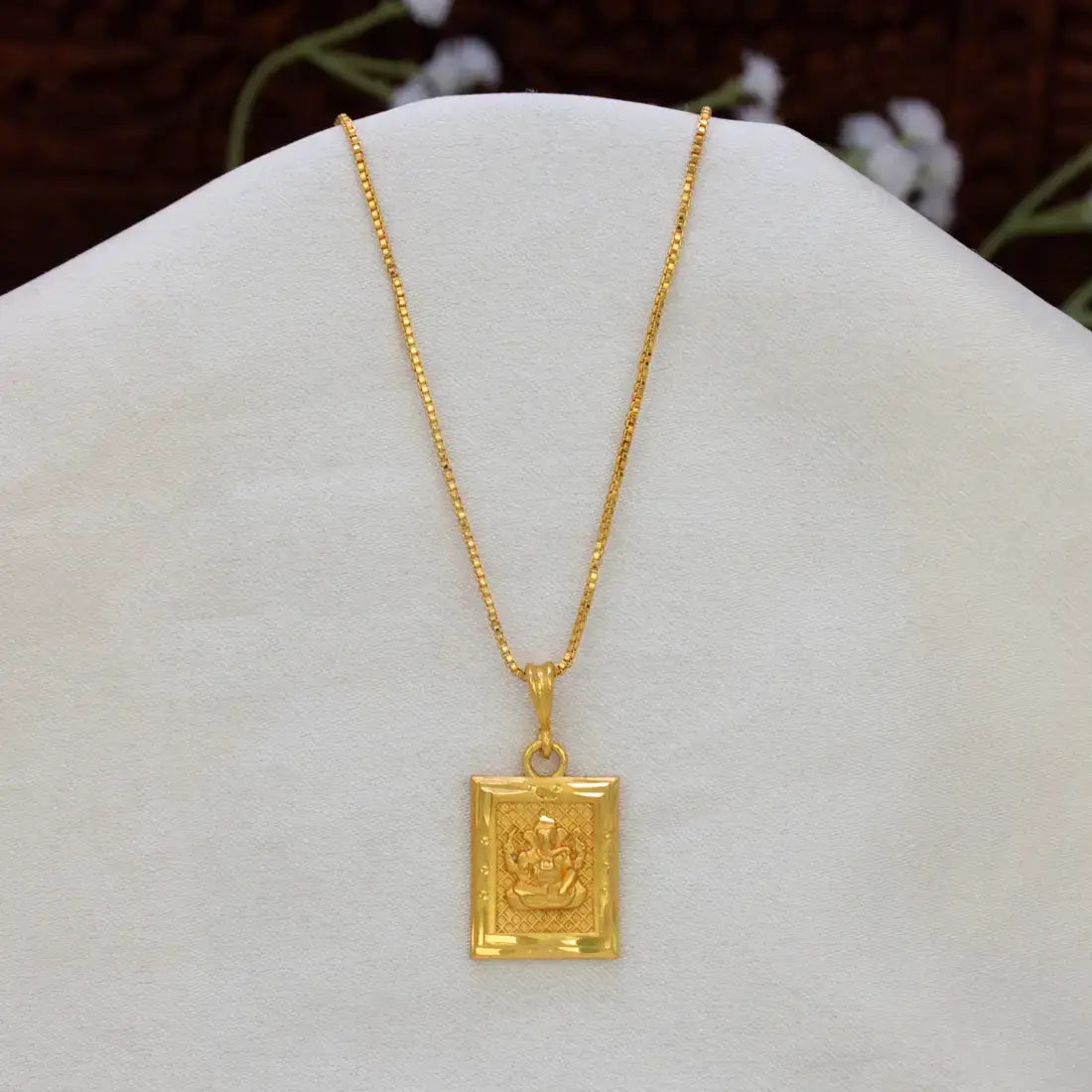 Devotional Gold Plated Rectangle Ganesha Pendant necklace featuring an embossed deity charm, displayed on a white jewelry bust.