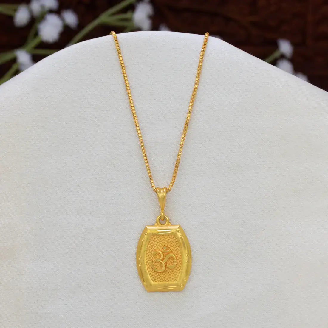 Devotional Unisex Gold Plated Rectangle Om Pendant featuring an Om symbol engraved on a textured rectangular pendant with chain, displayed on a white jewellery bust.