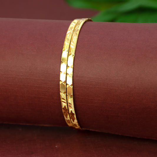 Contemporary Gold Plated Designer Cutting Bangles featuring a diamond-cut design on a maroon background.