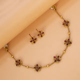 Floral Kemp Stone Antique Gold Choker Necklace Set with ruby-red flowers and matching earrings on a light background.