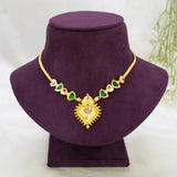 Gold-Plated Palakka Heart Pendant Necklace with a heart-shaped pendant and green Palakka and ruby stones, displayed on a purple velvet jewelry bust against a light background.