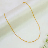 A delicate Gold-Plated Barrel Box Baby Chain with small cylindrical links, displayed on a soft, light-colored fabric background.