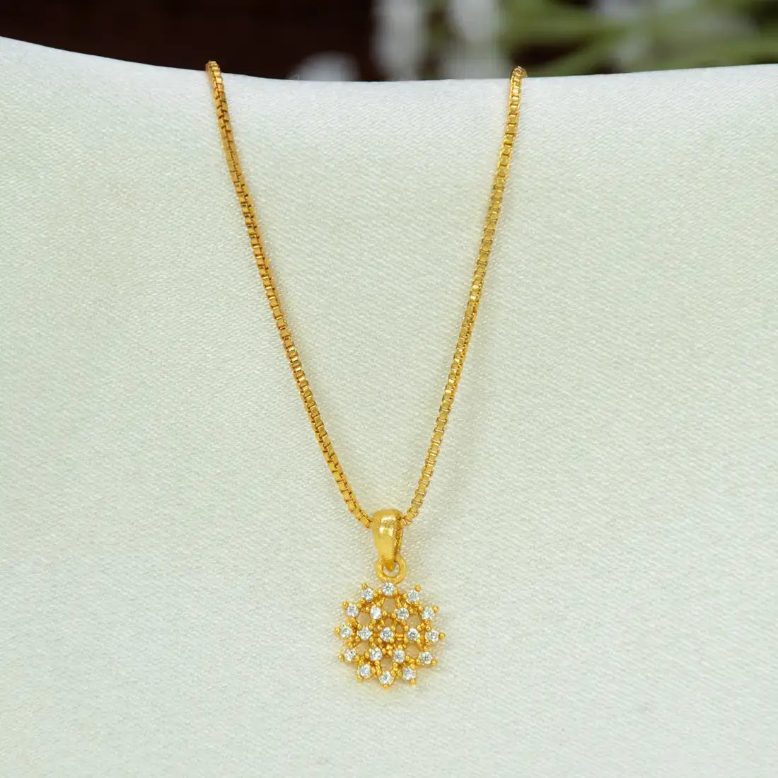 A gold chain necklace with a Gold-Plated Floral CZ Stone Pendant, displayed on a white jewellery bust.