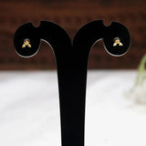 A pair of Gold-Plated Triple CZ Stone Second Stud Earrings, displayed on a black T-shaped jewelry stand against a softly blurred indoor background.