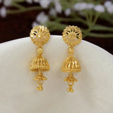 A pair of Gold-Plated Two-Step Floral Jhumka Earrings displayed on a white fabric stand. The earrings feature an intricate floral stud top and a dangling bell-shaped filigree dangle with small bead accents.
