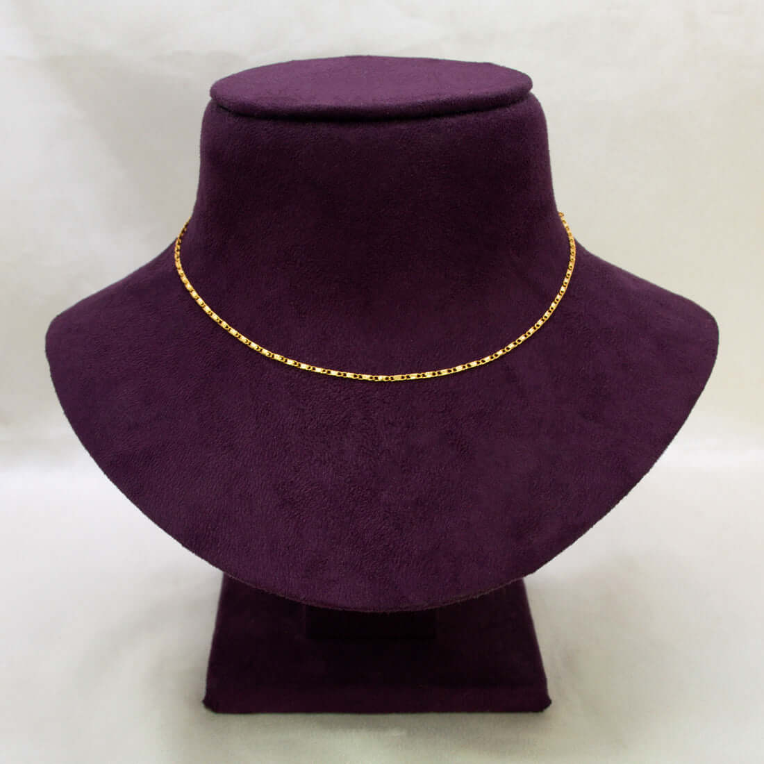 A Gold Plated Thin Titanic Chain for Kids displayed on a purple velvet jewelry bust against a light gray background.