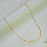 A Gold Plated Thin Titanic Chain for Kids necklace draped in a U-shape over a soft, light-colored fabric background.