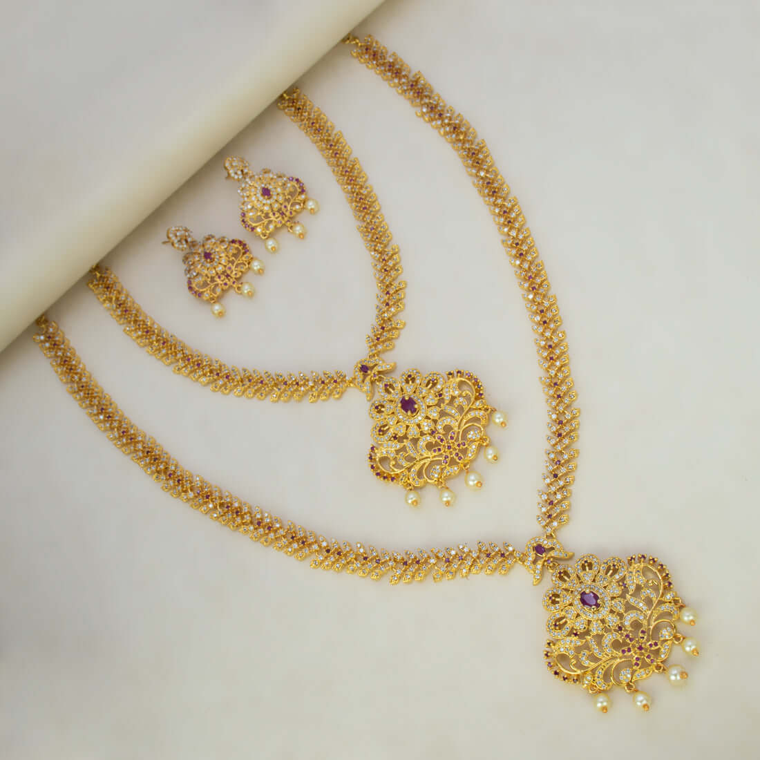 Gorgeous CZ Ruby Floral Wedding Jewellery Set featuring gold-plated necklaces and matching earrings.
