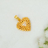 A Heart-Shaped Gold-Plated CZ Pendant For Women with a textured beaded border and a small central heart set with a clear stone, displayed on a textured white fabric background.