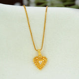 A gold heart pendant necklace with a Heart-Shaped Gold-Plated CZ pendant and a small clear heart in the center, displayed on a white jewelry bust.