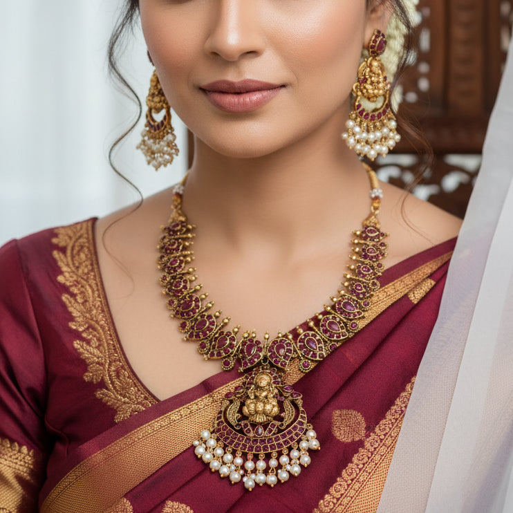 Antique Lakshmi Kemp Stone Mango Necklace Set with red stones and white pearl-like beads, arranged on a white surface with decorative props.