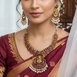 Antique Lakshmi Kemp Stone Mango Necklace Set with red stones and white pearl-like beads, arranged on a white surface with decorative props.